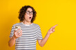 Photo portrait of pretty teen male gadget shocked point look empty space dressed stylish striped outfit isolated on yellow color background