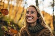Portrait of a beautiful young woman in the autumn forest, smiling
