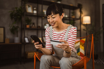 Japanese woman use credit card mobile phone online shopping at home