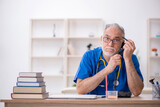 Fototapeta Nowy Jork - Old male doctor in telemedicine concept