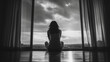 © CreativeIMGIdeas - A woman sits on the floor in front of a window, looking out at the cloudy sky