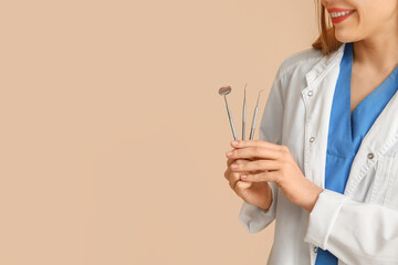 Canvas Print - Female dentist with dental tools on beige background. World Dentist Day