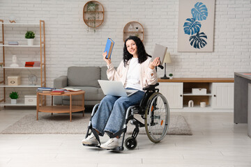 Canvas Print - Beautiful female student in wheelchair with modern laptop and books studying online at home