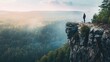 Person standing on cliff overlooking forest at dawn