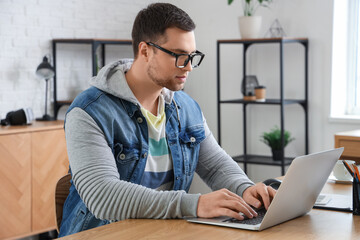 Portrait of male programmer working with laptop in office