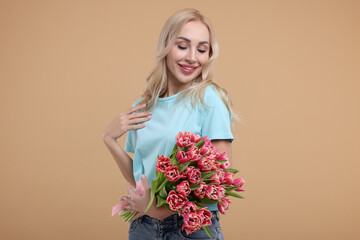 Wall Mural - Happy young woman with beautiful bouquet on beige background