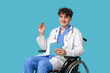 © Pixel-Shot - Young doctor on wheelchair with stethoscope and clipboard on blue background