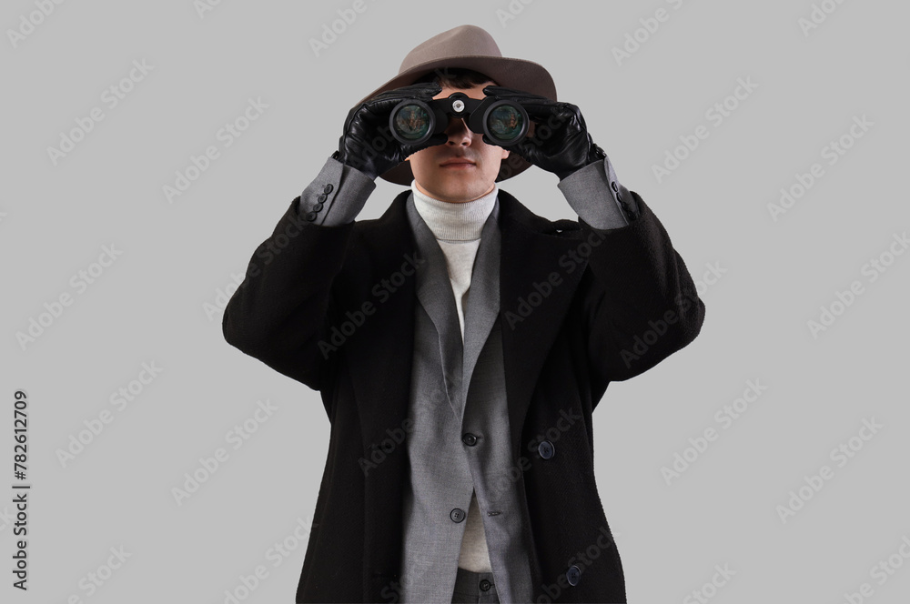 Male spy looking through binoculars on light background
