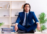 Fototapeta Sport - Young businessman sitting and working in the office
