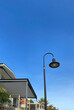 Street lamp, porches, balconies structure and roofs of buildings on blue sky background. Old floor light in the city. Black lamp post in the village.