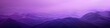 A stunning mountain range with vibrant purple hues in a gradient background. Banner. Copy space.