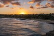 The sun sets over Shipwreck Beach and the Grand Hyatt Kauai Resort and Spa on the island of Kauai, Hawaii, USA.