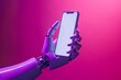 robot hand holding phone against bright colored background 