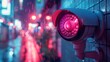© Vuk - A close-up of a security camera installed on a rainy day with red illumination amidst vibrant city street lights