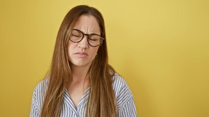 Sticker - Nervous young woman with blue eyes, wearing glasses frowning in doubt. upset, skeptic, she's a negative person facing problem against yellow isolated background.