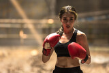 Fototapeta Natura - portrait of strong and confident young muay thai boxer woman