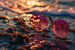 Glasses with pink lenses lie on the wet sand near the sea with a golden bokeh background. Relaxation, vacation concept. Generative ai