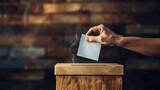 Fototapeta  - closeup image of Voter putting their vote into wooden ballot box on Election Day.