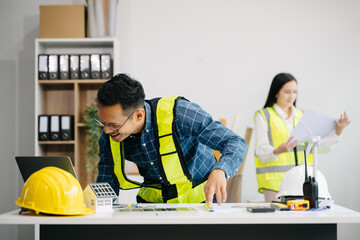 Engineer teams meeting working together wear worker helmets hardhat with on architectural project site and making model house. Asian industry professional team