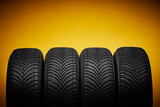 Fototapeta  - Car tires, winter wheels isolated on yellow background and screwdriver