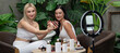 © InfiniteFlow - Two beautiful content creator making natural beauty and cosmetic tutorial on green garden. Beauty blogger show how to beauty care video to social medial audience using selfie stick.Panorama Blithe