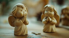 Two Wooden Angels Sitting On A Table, Suitable For Various Decorative Purposes