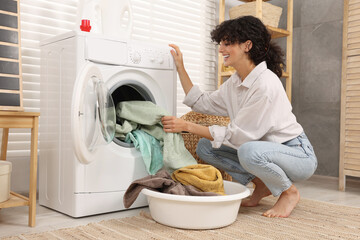 Canvas Print - Woman taking laundry out of washing machine indoors