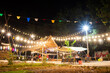 Camping-style beer garden decorated with orange lights
