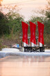 Three red beer towers on a black table with a forest background.