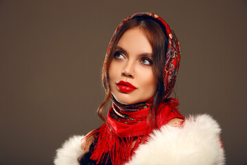 Wall Mural - Fashion woman portrait with traditional red headscarf. Russian beauty girl model with red lips makeup isolated on studio background.