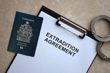 Fototapeta  - Passport of Canada and Extradition Agreement with handcuffs on table close up