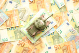 Fototapeta  - Many euro banknotes and tank. Lot of bills of European union currency and green tank close up