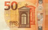 Fototapeta  - Fragment of one fifty euro money bill. Details of European union currency banknote of 50 euro close up