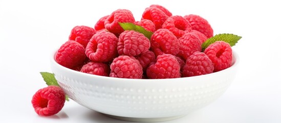 Close up of a bowl of raspberries with a leaf