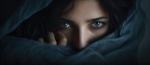 Woman With Dark Hair And Blue Eyes Concealing Beneath Blanket