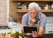 © peopleimages.com - Senior man, tablet and vegetables for cooking wholesome, healthy and nutritional food at home. Retired male, ingredients and digital device for researching diet, recipes and delicious vegan meals