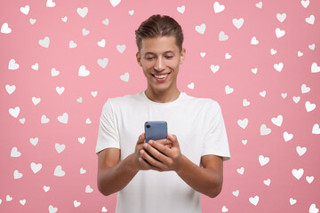 Poster - Long distance love. Man chatting with sweetheart via smartphone on pink background. Hearts around him