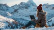 Woman working on laptop in snowy mountains