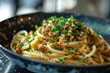 Appetizing close-up shot of spaghetti Bolognese sprinkled with parsley on a stylish black plate