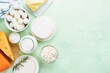 Dairy products or farm products. Fresh organic dairy products milk, cottage cheese, butter, cream, yogurt, sour cream and mozzarella on a light green slate, stone or concrete background. Top view.