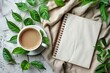 simplicity of a top-down view flat lay photograph, where a blank white spiral notebook is surrounded by coffee cups and fresh green leaves on a table, all set against a clean white background