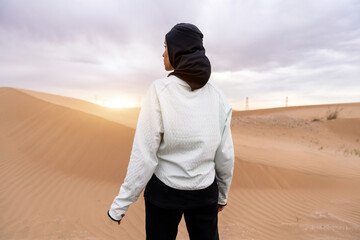 Wall Mural - Beautiful arab sportive woman wearing hijab training outdoors in the desert