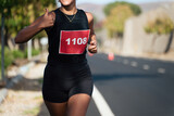 Fototapeta  - Marathon runner woman gesturing thumbs up outdoors in a city outskirts