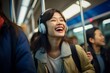 A young woman beams with joy as she listens to music through her headphones while riding the subway,