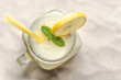 Fresh lemonade in glass jar on sand beach. Refreshing lemon drink, top view.