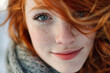Portrait of a cheerful redheaded woman with bright blue eyes and freckles.