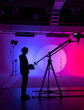 Silhouette of a cameraman against the background of neon studio light Backstage shot.