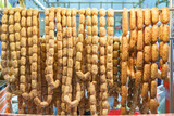 Fototapeta Miasta - Pork and rice sausage or fermented hot dog northeastern isan thai style hanging in hawker stall for sale
