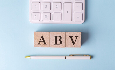 Wall Mural - ABV word on wooden block with pen and calculator on blue background