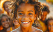 © Viktoriia - Smiling African American LIttle boy with dreadlocks in front of a crowd of children